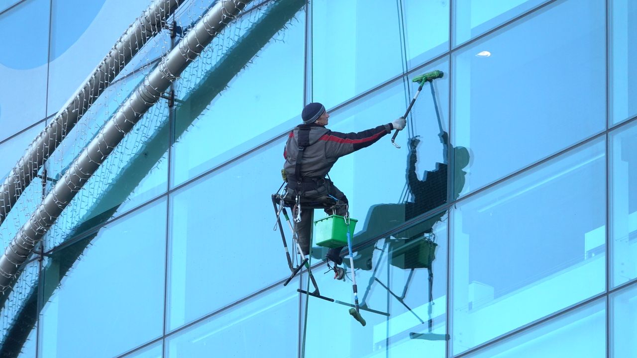 heros-img Window cleaner works on a high-rise glass building, ensuring spotless results.